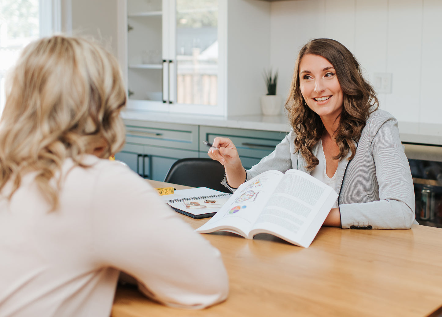 Ewa Reid consulting a client sitting at a table showing the client information. 